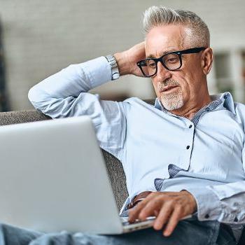 A gray-haired man shops for a new car using the AutoSmart website.